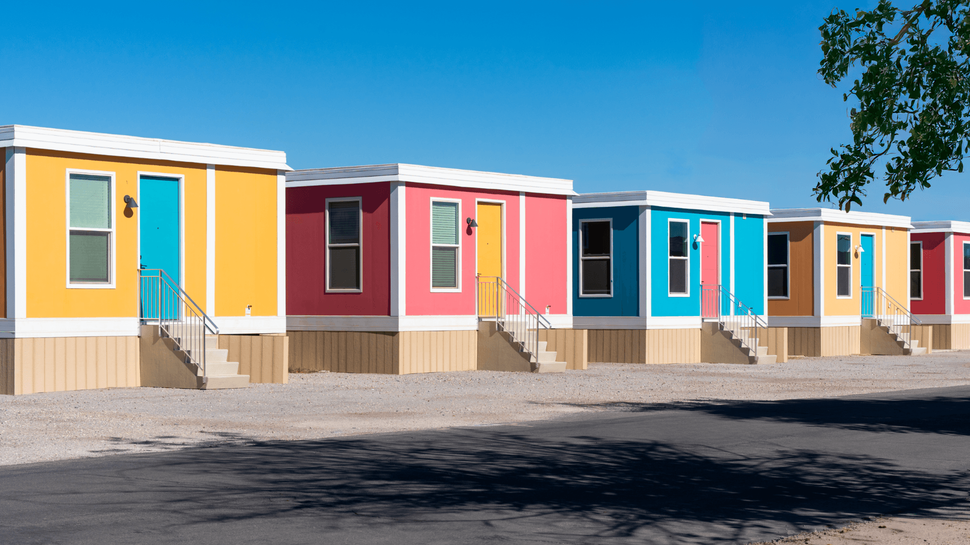 A row of completed BOXABL Casitas in a range of exterior colors